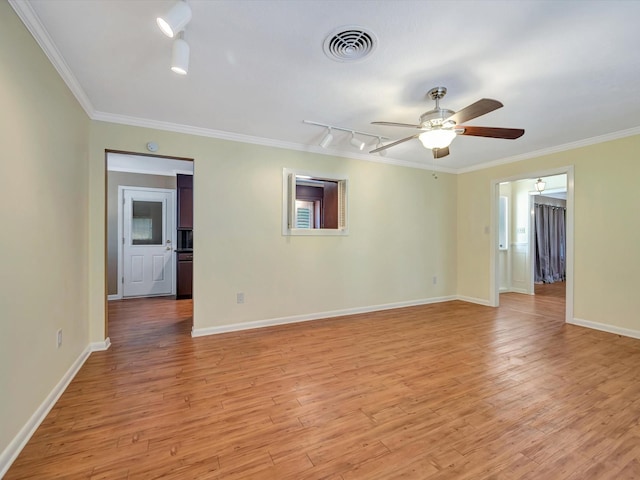 208 Burnett Dr, Baytown, TX 77520 - spare room featuring track lighting, ornamental molding, light wood-style flooring, and visible vents