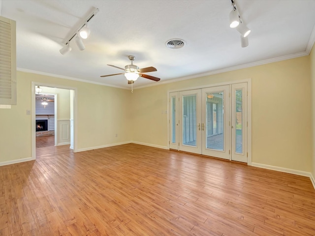208 Burnett Dr, Baytown, TX 77520 - unfurnished room with a fireplace, a ceiling fan, rail lighting, and light wood-style floors