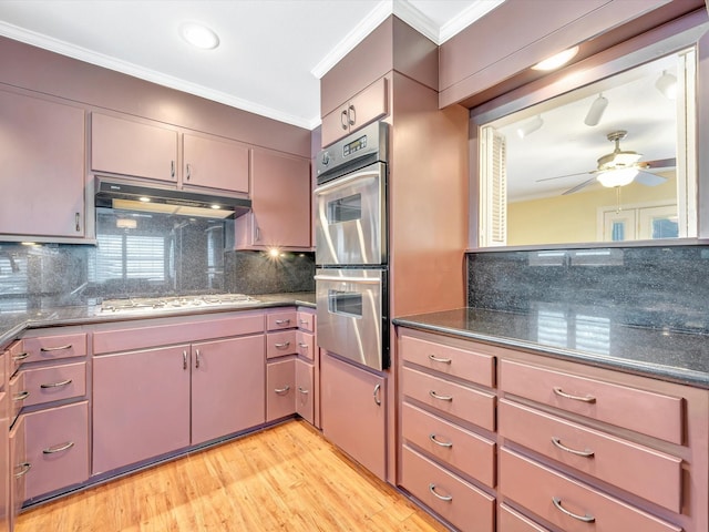208 Burnett Dr, Baytown, TX 77520 - kitchen with ceiling fan, stainless steel double oven, crown molding, gas stovetop, and under cabinet range hood
