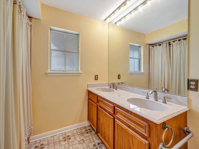 208 Burnett Dr, Baytown, TX 77520 - full bath with double vanity, baseboards, a sink, and tile patterned floors
