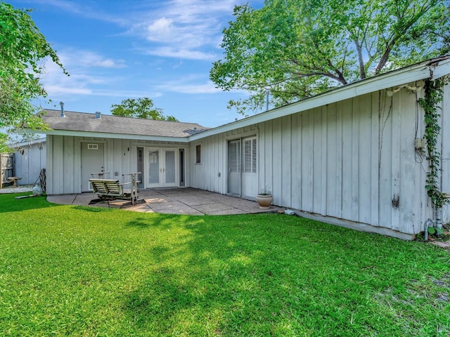 208 Burnett Dr, Baytown, TX 77520 - back of property featuring board and batten siding, a lawn, french doors, and a patio area