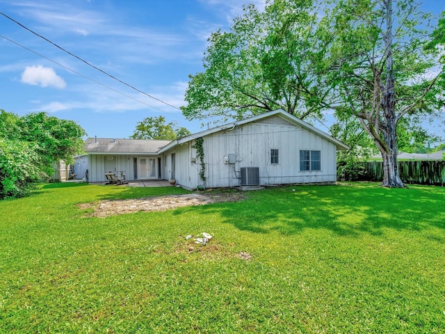 208 Burnett Dr, Baytown, TX 77520 - rear view of house with board and batten siding, a lawn, central AC unit, fence, and a patio