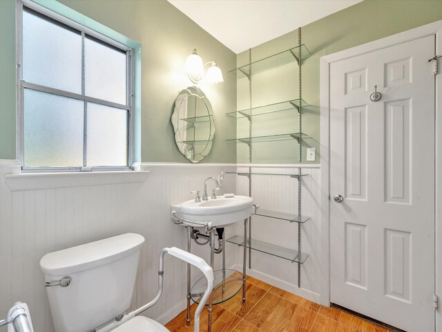 208 Burnett Dr, Baytown, TX 77520 - half bath with wood finished floors, plenty of natural light, a wainscoted wall, and toilet
