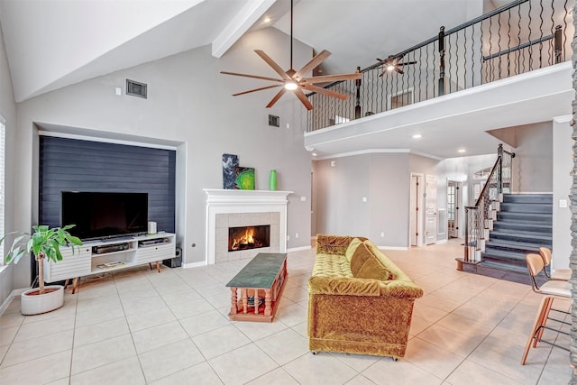 16015 Maycrest Ct, Tomball, TX 77377 - living area featuring ceiling fan, a tiled fireplace, tile patterned flooring, stairway, and high vaulted ceiling