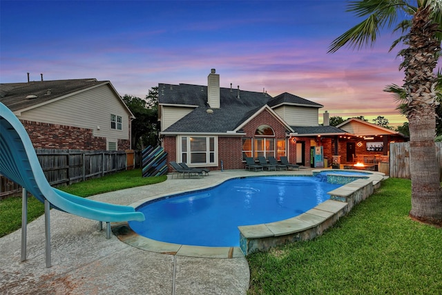 16015 Maycrest Ct, Tomball, TX 77377 - view of swimming pool featuring a patio, a fenced backyard, a water slide, a yard, and a pool with connected hot tub