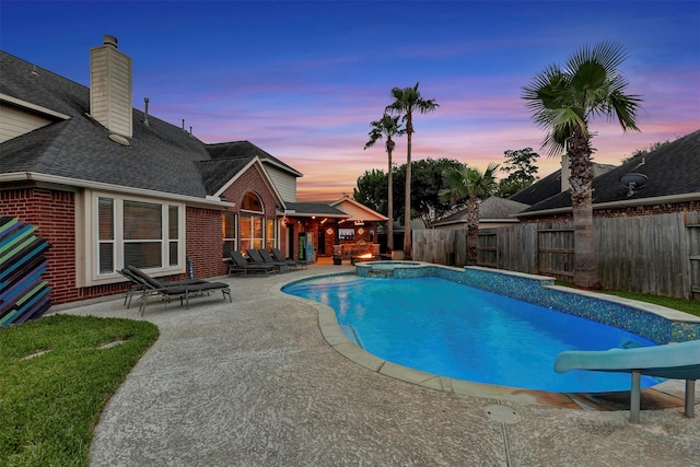 16015 Maycrest Ct, Tomball, TX 77377 - pool at dusk featuring a fenced backyard, a water slide, a pool with connected hot tub, and a patio