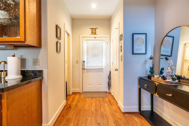 entryway featuring baseboards and light wood-type flooring
