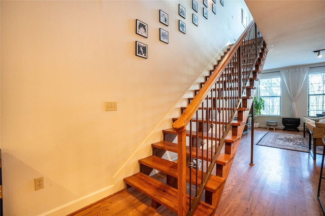 staircase with wood finished floors and baseboards