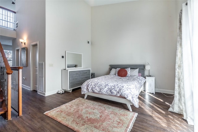 bedroom with a towering ceiling, baseboards, and multiple windows