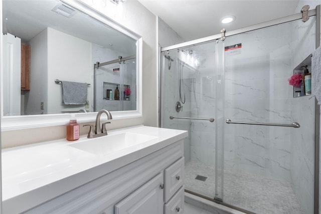 bathroom featuring a marble finish shower, visible vents, and vanity