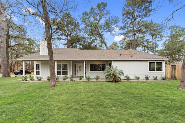 ranch-style house featuring fence, roof with shingles, a chimney, and a front yard