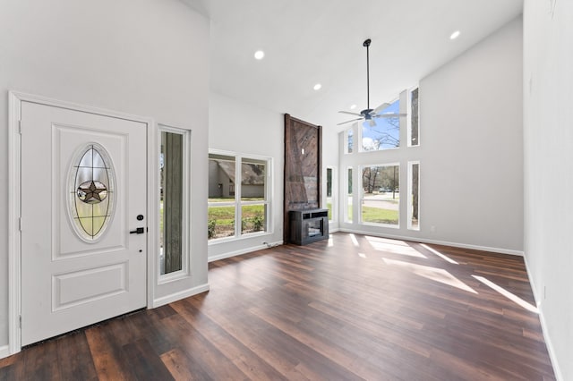 foyer entrance featuring dark wood-style floors, high vaulted ceiling, a wealth of natural light, and ceiling fan