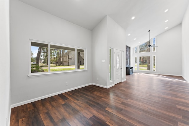 unfurnished living room featuring high vaulted ceiling, baseboards, and plenty of natural light
