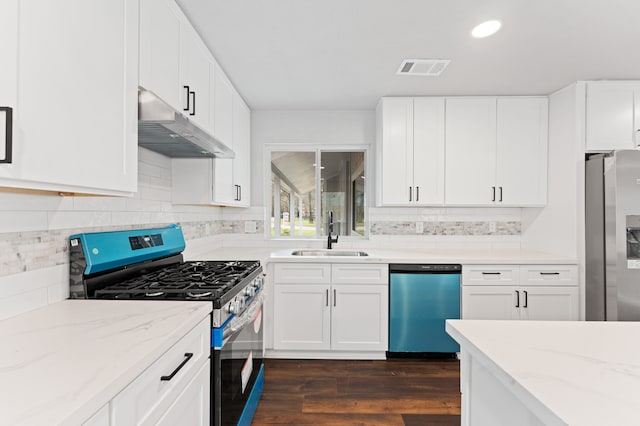 kitchen with dark wood-style floors, light stone countertops, a sink, stainless steel appliances, and under cabinet range hood