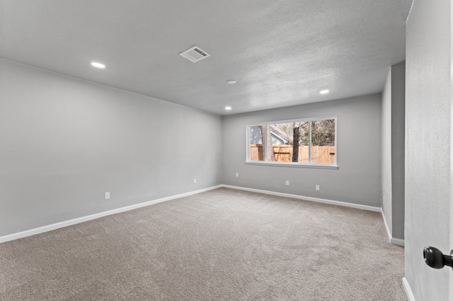 carpeted spare room featuring baseboards, visible vents, and recessed lighting