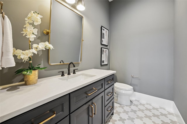 bathroom with vanity, toilet, tile patterned flooring, and baseboards