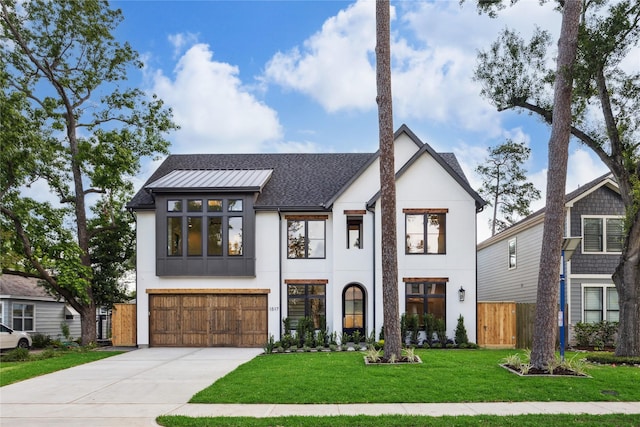 view of front facade with fence, stucco siding, concrete driveway, and an attached garage