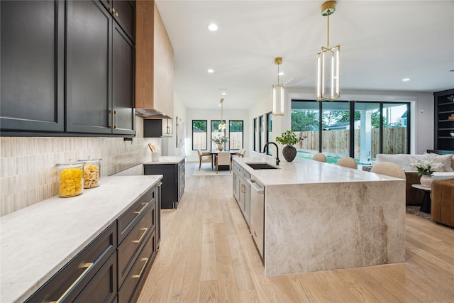 kitchen with recessed lighting, a sink, tasteful backsplash, light wood-style flooring, and dishwasher
