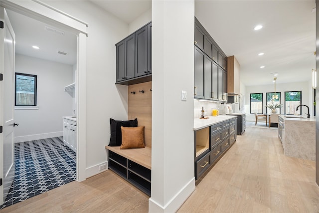 mudroom with recessed lighting, a sink, light wood-style floors, visible vents, and baseboards