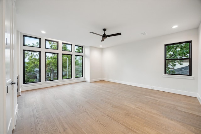 unfurnished room with light wood-type flooring, a ceiling fan, and a healthy amount of sunlight