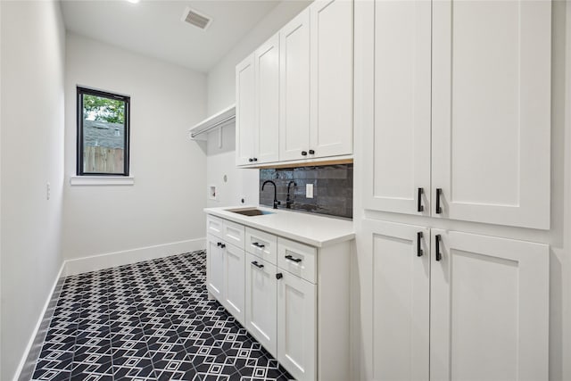 laundry room featuring hookup for a washing machine, a sink, cabinet space, and baseboards