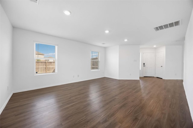 empty room with visible vents, recessed lighting, baseboards, and dark wood-style floors