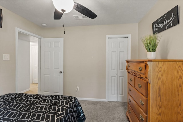 bedroom with a closet, ceiling fan, visible vents, baseboards, and light colored carpet