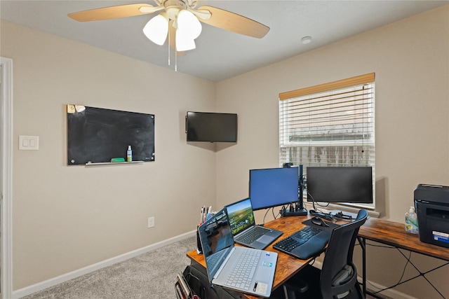 carpeted office featuring a ceiling fan and baseboards