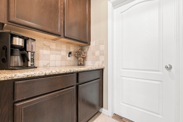 21735 Lozar Dr, Spring, TX 77379 - kitchen with light stone counters, dark brown cabinetry, and tasteful backsplash