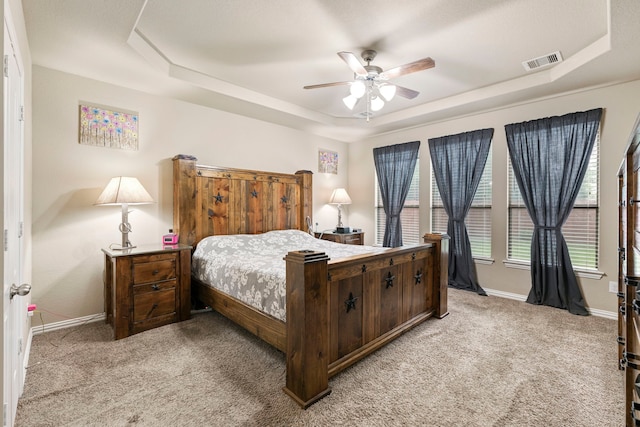 21735 Lozar Dr, Spring, TX 77379 - bedroom with light colored carpet, a ceiling fan, baseboards, a tray ceiling, and visible vents
