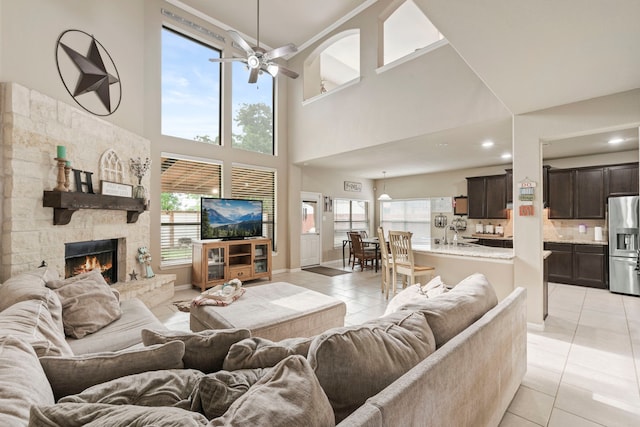 21735 Lozar Dr, Spring, TX 77379 - living room with light tile patterned floors, a high ceiling, a fireplace, and a ceiling fan