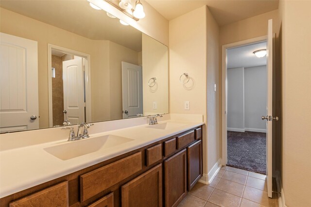 2623 Holbrook Springs Ln, League City, TX 77573 - bathroom with tile patterned floors, baseboards, double vanity, and a sink