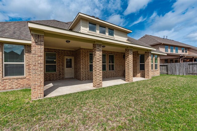 2623 Holbrook Springs Ln, League City, TX 77573 - rear view of house featuring a yard, brick siding, fence, a shingled roof, and a patio area