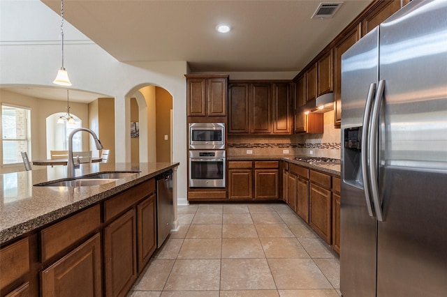 2623 Holbrook Springs Ln, League City, TX 77573 - kitchen featuring tasteful backsplash, arched walkways, appliances with stainless steel finishes, a sink, and visible vents
