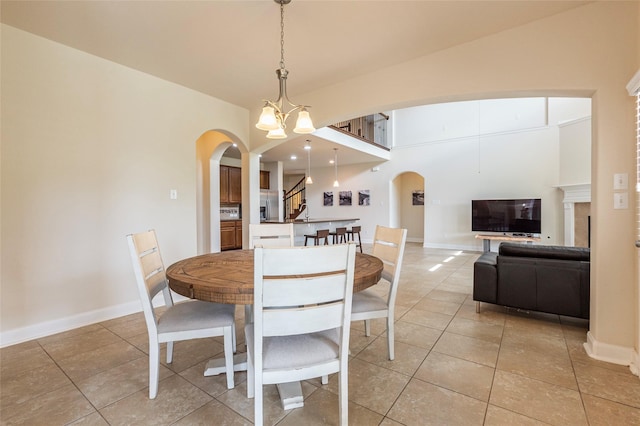 2623 Holbrook Springs Ln, League City, TX 77573 - dining space featuring light tile patterned floors, arched walkways, a high ceiling, and baseboards
