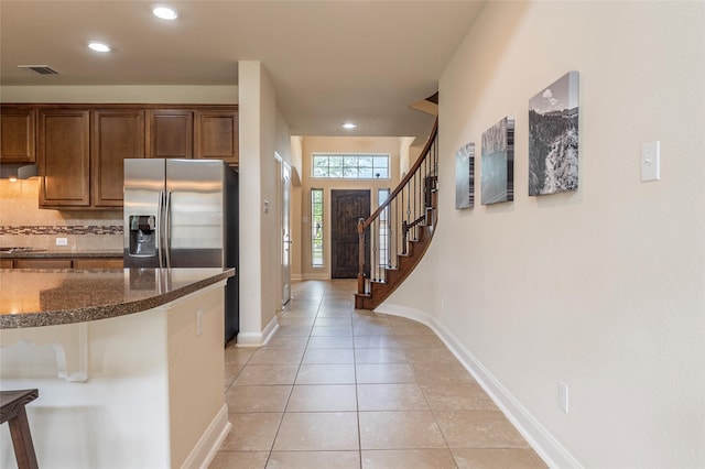 2623 Holbrook Springs Ln, League City, TX 77573 - kitchen with dark stone counters, light tile patterned floors, stainless steel fridge, visible vents, and backsplash