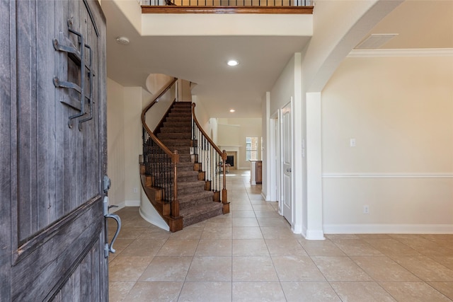 2623 Holbrook Springs Ln, League City, TX 77573 - entrance foyer featuring arched walkways, light tile patterned floors, baseboards, stairway, and crown molding