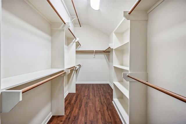 walk in closet with dark wood-style flooring and lofted ceiling