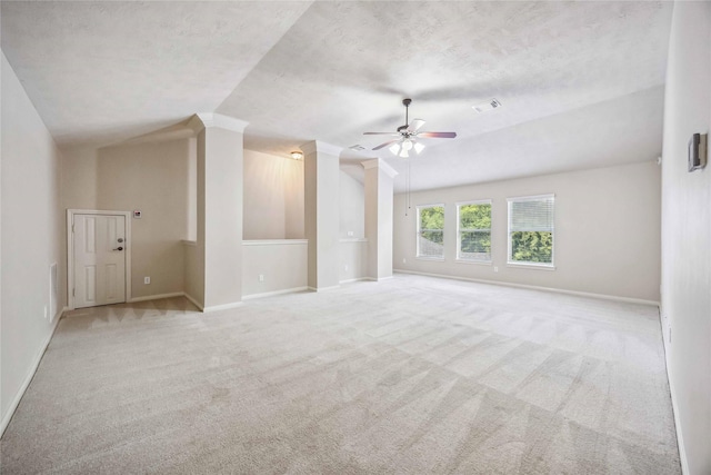 carpeted spare room featuring ceiling fan, lofted ceiling, baseboards, and a textured ceiling