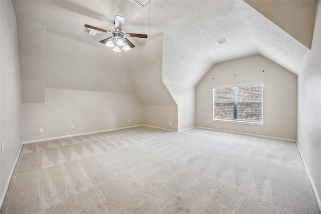 additional living space featuring attic access, carpet, lofted ceiling, ceiling fan, and baseboards