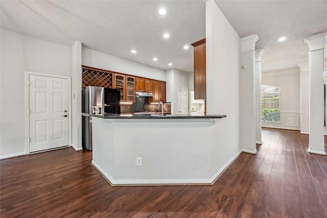 kitchen with under cabinet range hood, dark countertops, stainless steel fridge with ice dispenser, backsplash, and recessed lighting
