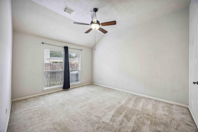 carpeted spare room featuring ceiling fan, baseboards, and lofted ceiling