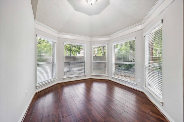 unfurnished sunroom featuring baseboards, wood finished floors, and crown molding