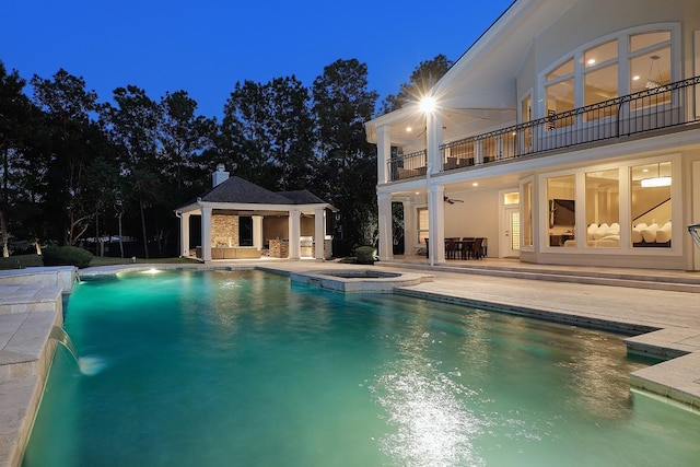 8 Autumn Cres, The Woodlands, TX 77381 - pool at night with a gazebo, ceiling fan, a pool with connected hot tub, and a patio area