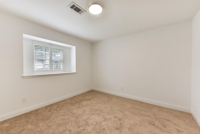 empty room featuring visible vents, light carpet, and baseboards