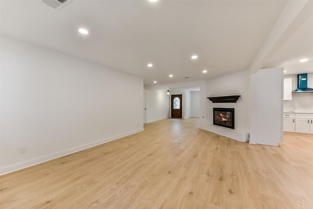 unfurnished living room with recessed lighting, a brick fireplace, visible vents, light wood-style flooring, and baseboards