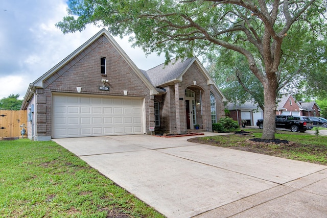 traditional-style house with driveway, an attached garage, fence, and brick siding