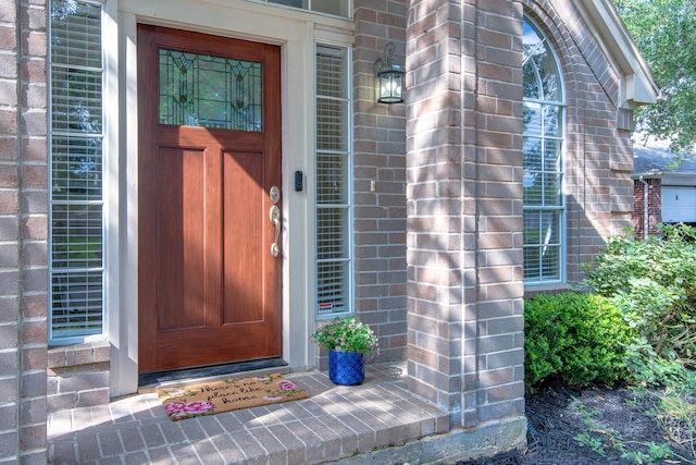 entrance to property featuring brick siding