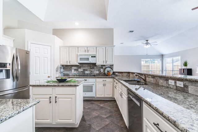 kitchen featuring a sink, ceiling fan, white appliances, white cabinets, and lofted ceiling