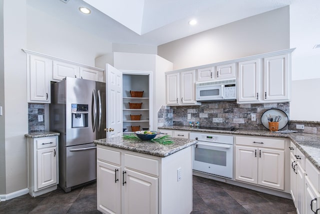 kitchen featuring a kitchen island, white cabinets, backsplash, and white appliances
